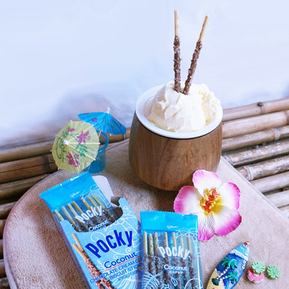 A package of Pocky Coconut chocolate on a beige tray next to a coconut cup filled with vanilla ice cream and two Pocky Coconut sticks.