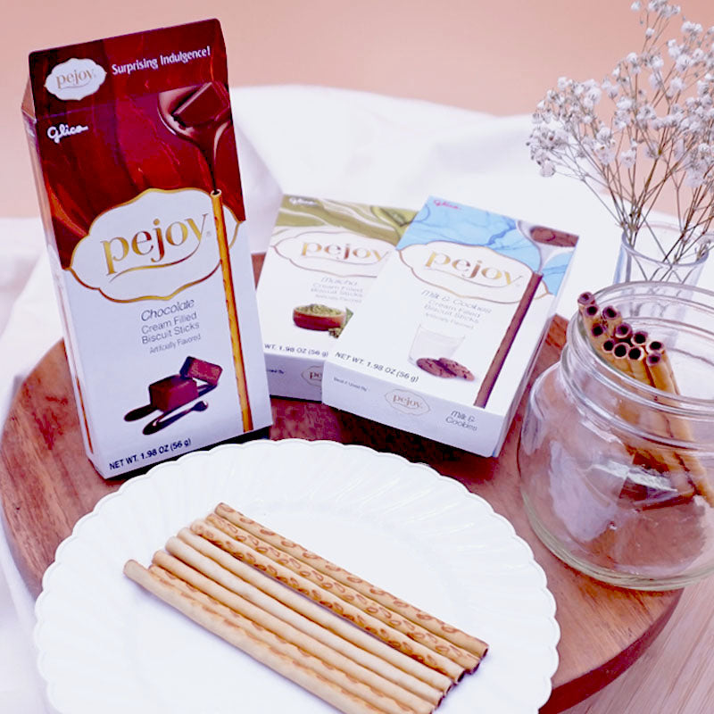 A box of Pejoy Chocolate, Matcha, and Milk & Cookies on a wooden tray.