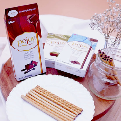 A box of Pejoy Chocolate, Matcha, and Milk & Cookies on a wooden tray.
