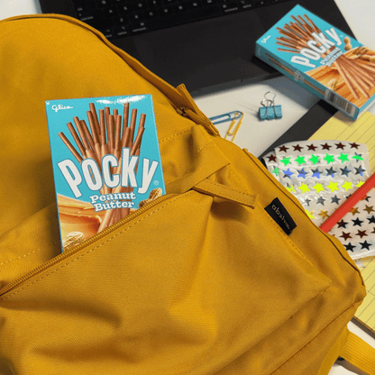 Yellow backpack with Pocky Peanut Butter packaging in a back pocket.