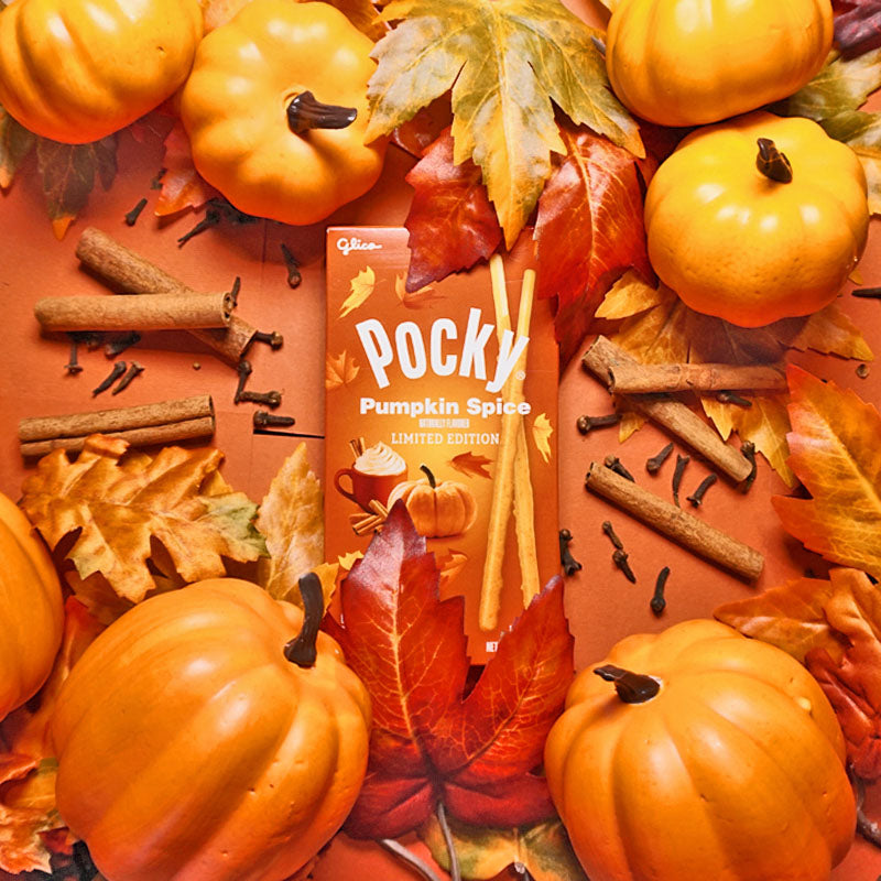 An image of Pocky Pumpkin Spice box surrounded by pumpkins, cinnamon sticks, and fall leaves, with orange background.